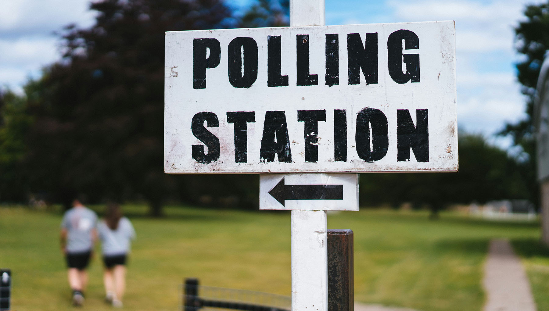 a sign points voters toward the polling place a sign points voters toward the polling place